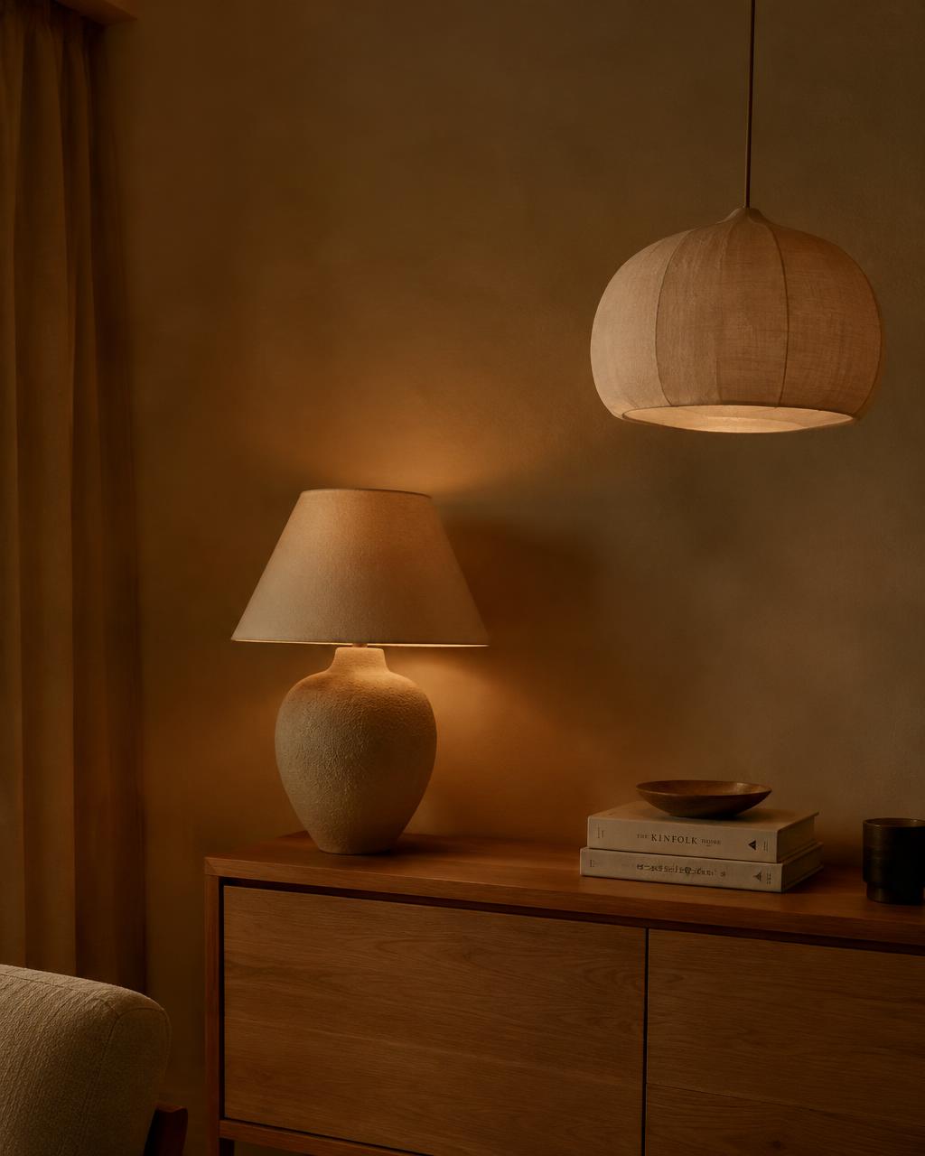 Ceramic table lamp and linen pendant glowing warmly